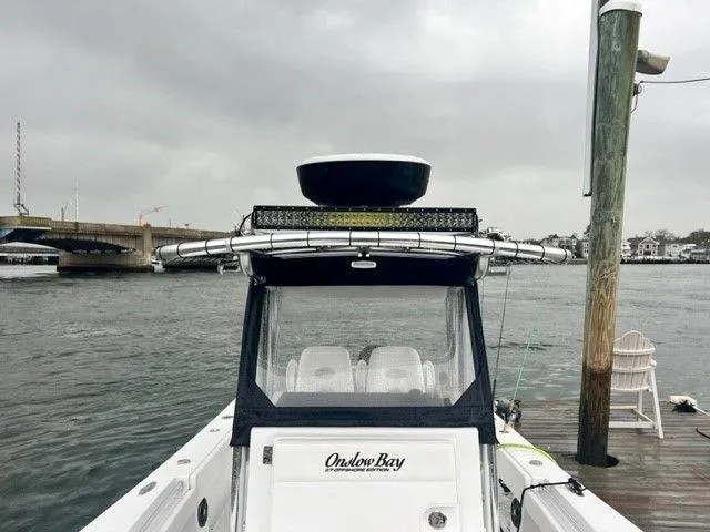 Slide: The Image of 2023 Onslow Bay 27 Offshore boat docked by a waterfront under cloudy skies. - 7