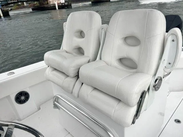 Slide: The Image of 2023 Onslow Bay 27 Offshore boat with plush white seating by the water. - 9