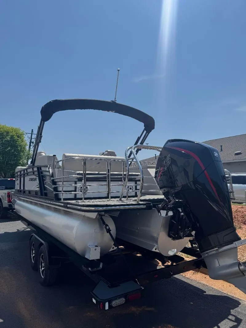 Slide: The Image of 2022 Starcraft SLS 3 Q DH pontoon boat with outboard motor, parked on trailer. - 4
