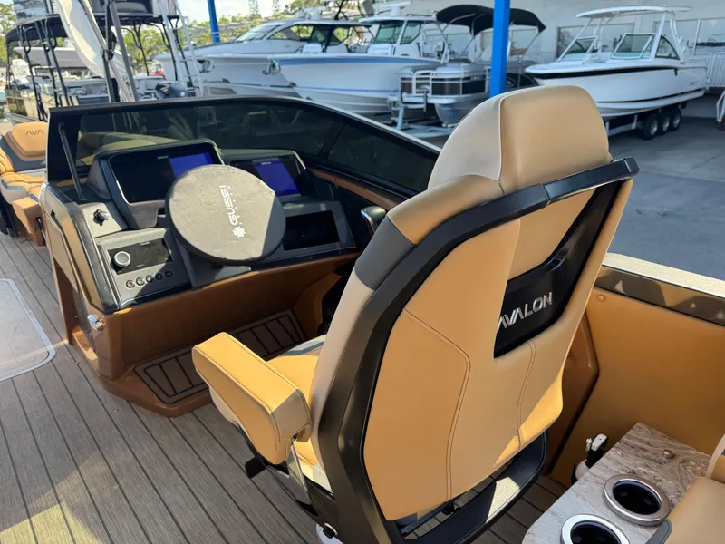 Slide: The Image of 2025 Avalon Excalibur 27' boat interior with modern helm and tan seating. - 31