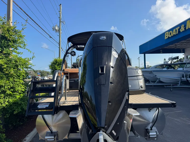 Slide: The Image of 2025 Avalon Excalibur 27' boat with powerful outboard motor, parked near dealership. - 8