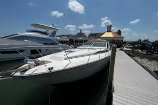 Slide: The Image of 1990 Sea Ray 390 Express Cruiser docked at marina under blue sky. - 0