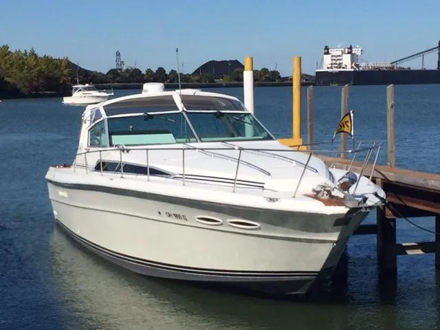 Slide: The Image of 1990 Sea Ray 390 Express Cruiser docked in a serene marina setting. - 1
