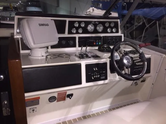 Slide: The Image of 1990 Sea Ray 390 Express Cruiser helm with Simrad navigation system and classic controls. - 14
