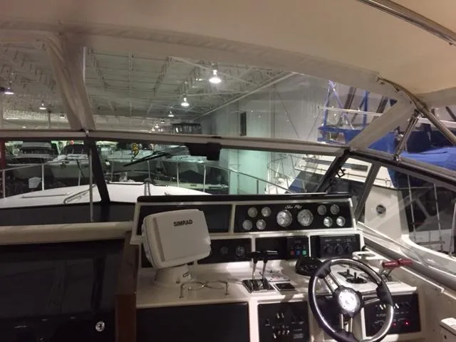 Slide: The Image of 1990 Sea Ray 390 Express Cruiser helm with navigation equipment in a boat storage facility. - 15