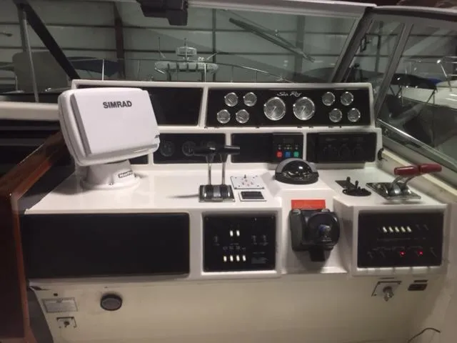 Slide: The Image of 1990 Sea Ray 390 Express Cruiser helm with Simrad navigation system and control panel. - 16