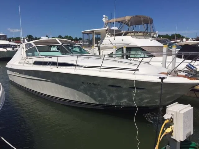 Slide: The Image of 1990 Sea Ray 390 Express Cruiser docked at a marina under clear blue skies. - 2