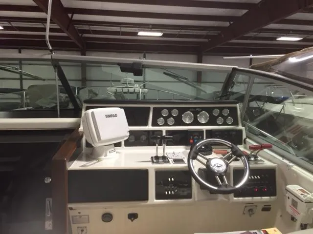 Slide: The Image of 1990 Sea Ray 390 Express Cruiser helm with steering wheel and navigation equipment. - 25
