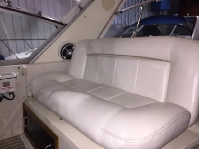 Slide: The Image of 1990 Sea Ray 390 Express Cruiser interior with white leather seating. - 27