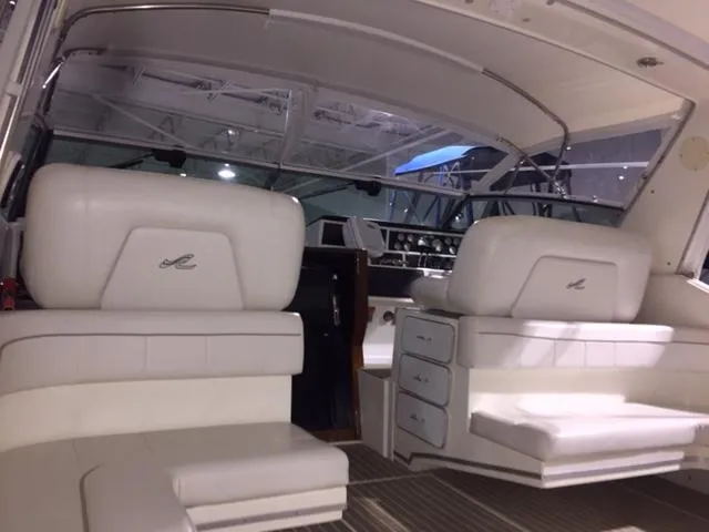 Slide: The Image of 1990 Sea Ray 390 Express Cruiser interior with white seating and dashboard view. - 35