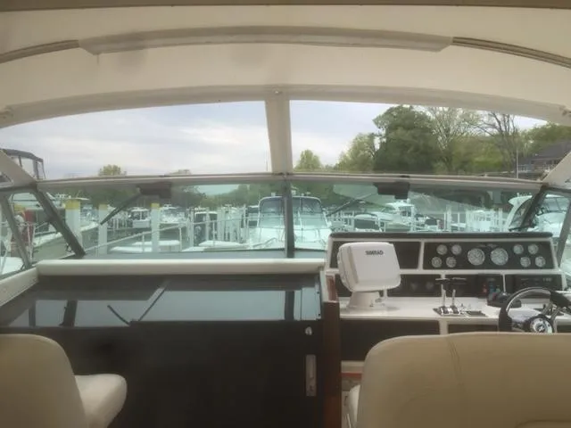 Slide: The Image of 1990 Sea Ray 390 Express Cruiser cockpit with dashboard and marina view. - 37