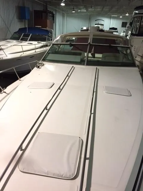 Slide: The Image of 1990 Sea Ray 390 Express Cruiser in indoor storage, showcasing sleek deck design. - 6