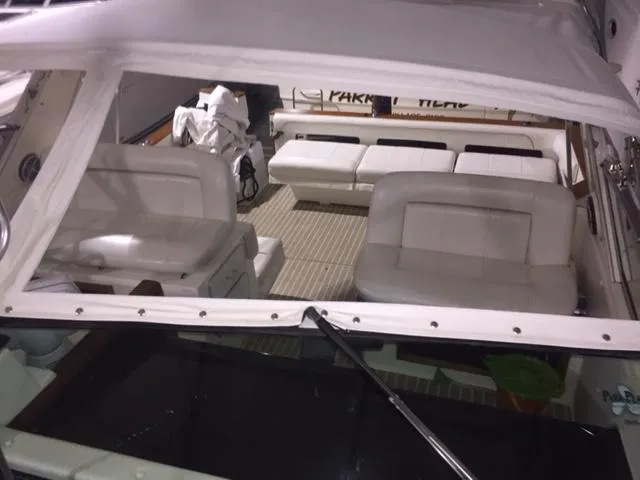 Slide: The Image of 1990 Sea Ray 390 Express Cruiser interior with white seating and canopy. - 8