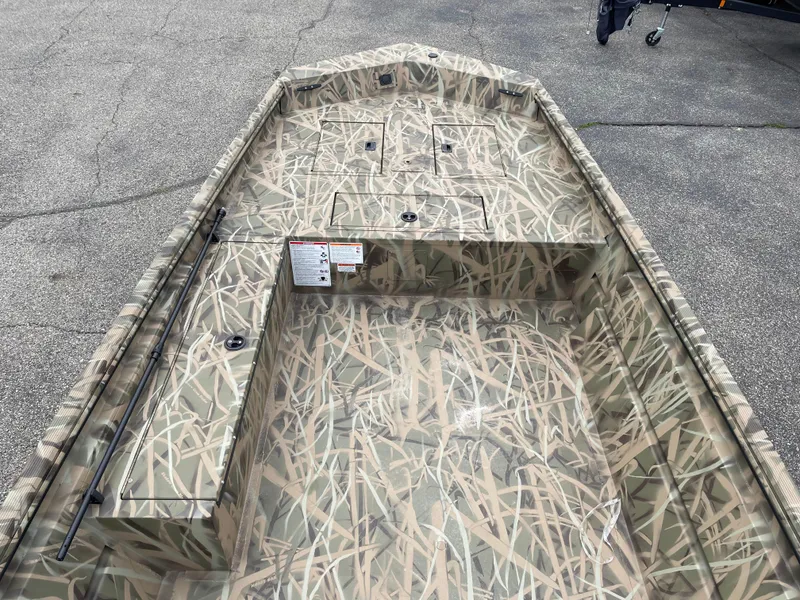 Slide: The Image of 2025 Crestliner 1760 Retriever Jon Deluxe boat with camouflage design on a concrete surface. - 6
