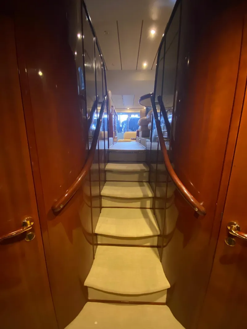 Slide: The Image of Staircase inside 2001 Fairline Squadron 55 yacht with wooden paneling and elegant design. - 16