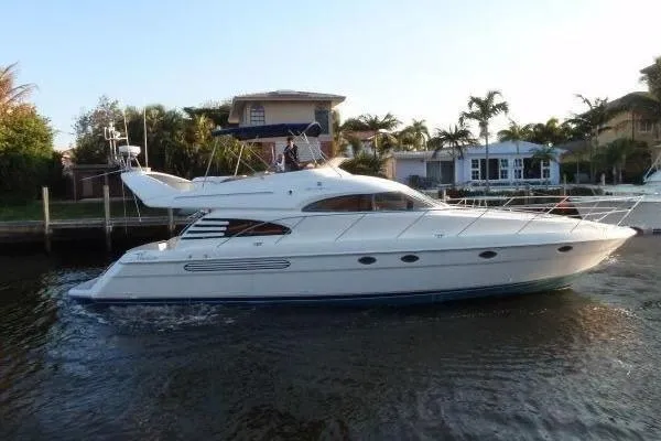 Slide: The Image of 2001 Fairline Squadron 55 yacht cruising near waterfront homes. - 2