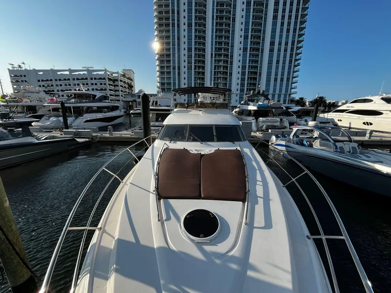 Slide: The Image of 2001 Fairline Squadron 55 yacht docked at marina, with modern high-rise buildings in background. - 3
