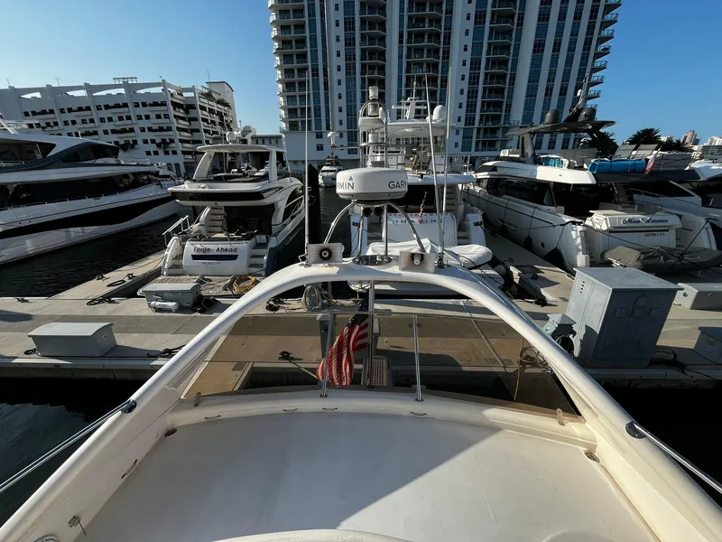 Slide: The Image of 2001 Fairline Squadron 55 yacht docked at a marina with modern buildings in the background. - 4