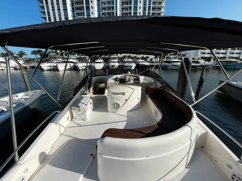 Slide: The Image of 2001 Fairline Squadron 55 yacht interior with seating, docked in marina, modern buildings in background. - 9