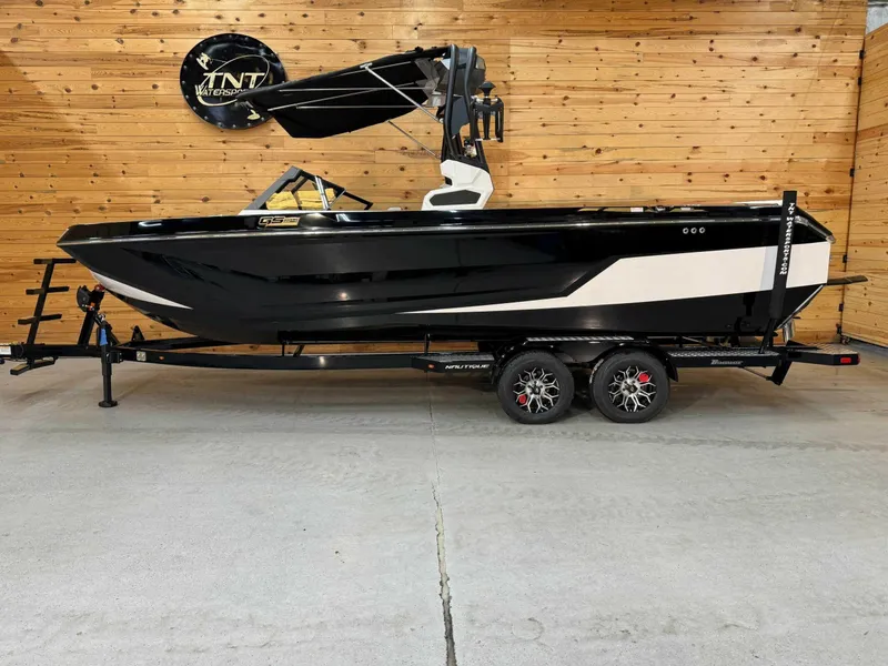 Slide: The Image of 2024 Nautique GS24 boat on trailer, black and white design, displayed indoors. - 1