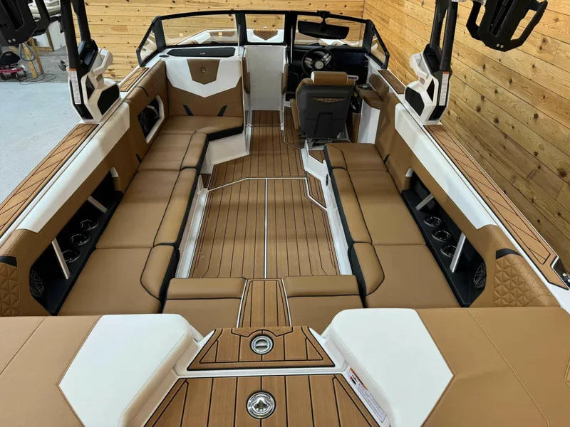 Slide: The Image of 2024 Nautique GS24 boat interior with tan seating and wood accents, showcasing luxury design. - 5
