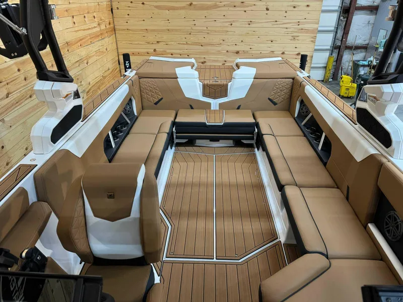 Slide: The Image of 2024 Nautique GS24 boat interior with tan seating and wood paneling. - 8