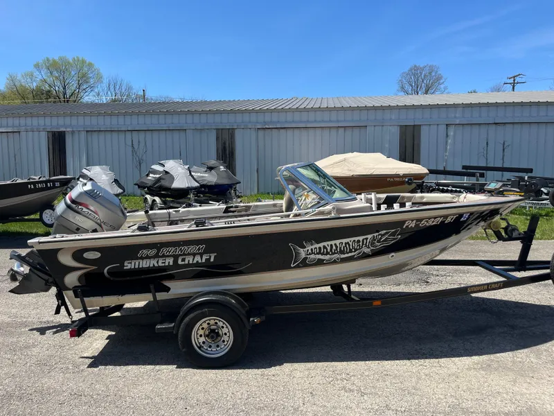 Slide: The Image of 1997 Smoker Craft 170 PHANTOM boat on trailer, parked outdoors. - 1