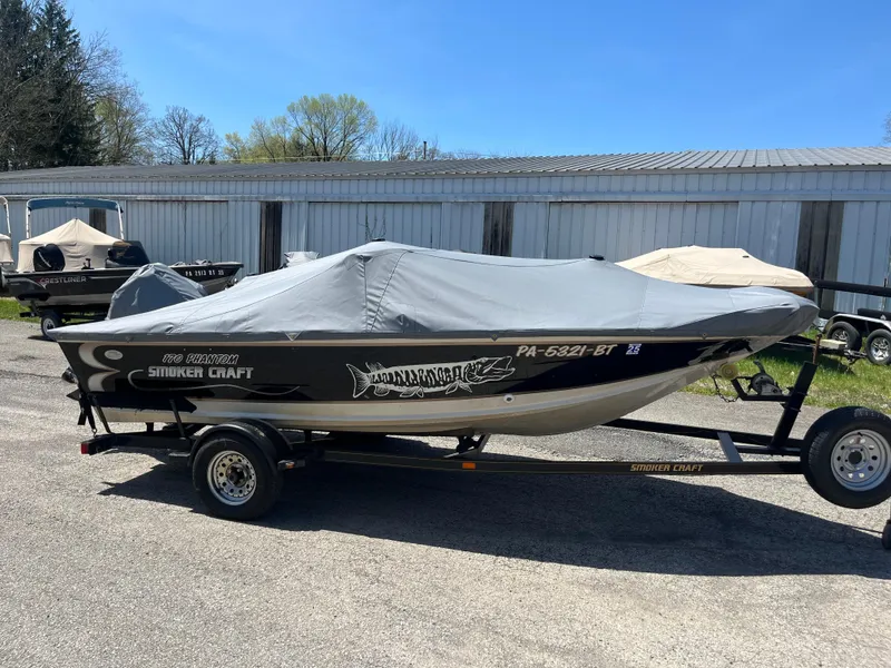 Slide: The Image of 1997 Smoker Craft 170 PHANTOM boat on trailer, covered, parked outdoors. - 5