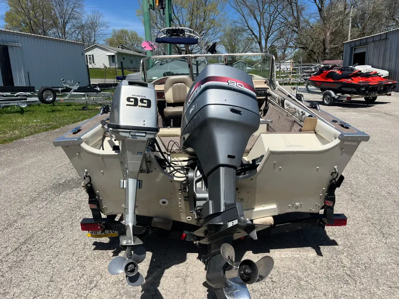 Slide: The Image of 1997 Smoker Craft 170 PHANTOM boat with dual outboard motors, parked outdoors. - 7