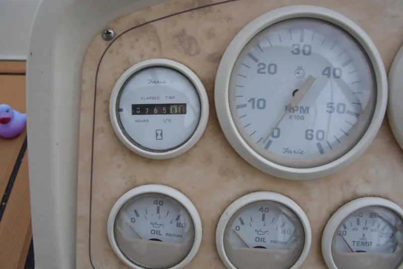 Slide: The Image of Instrument panel of 1997 Cruisers Yachts 3120 Aria, featuring RPM and oil pressure gauges. - 11