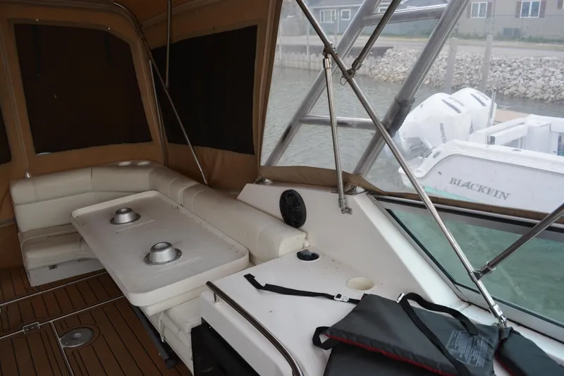 Slide: The Image of 1997 Cruisers Yachts 3120 Aria interior with seating, table, and covered deck area. - 14