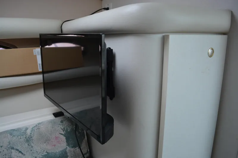 Slide: The Image of Wall-mounted TV inside 1997 Cruisers Yachts 3120 Aria cabin, showcasing modern amenities. - 26