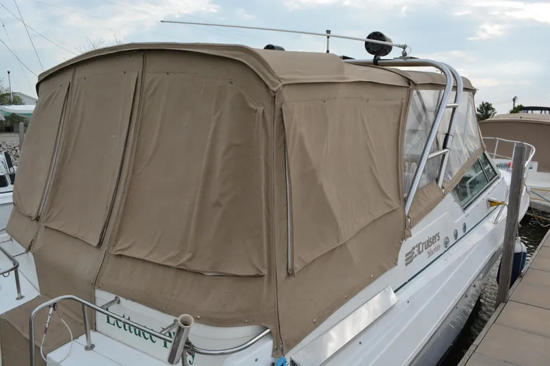Slide: The Image of 1997 Cruisers Yachts 3120 Aria with beige canvas cover docked at marina. - 6