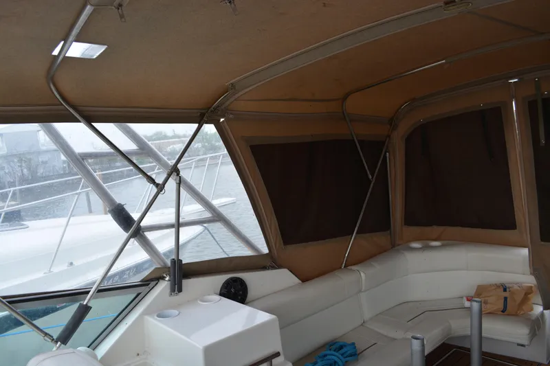 Slide: The Image of 1997 Cruisers Yachts 3120 Aria interior with seating and helm, featuring brown canopy. - 17