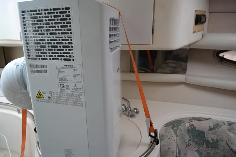 Slide: The Image of Portable air conditioner inside 1997 Cruisers Yachts 3120 Aria cabin, secured with orange strap. - 22