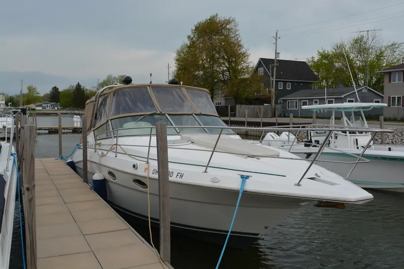 Slide: The Image of 1997 Cruisers Yachts 3120 Aria docked at a marina, surrounded by other boats. - 4