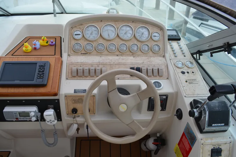 Slide: The Image of 1997 Cruisers Yachts 3120 Aria helm with gauges, steering wheel, and navigation equipment. - 9