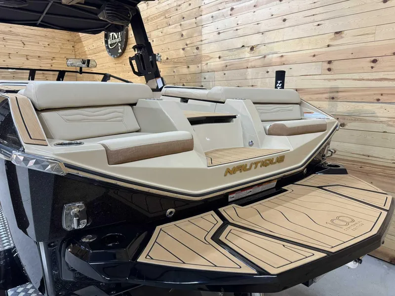 Slide: The Image of 2025 Nautique G25 boat interior with beige seating and wooden accents. - 3