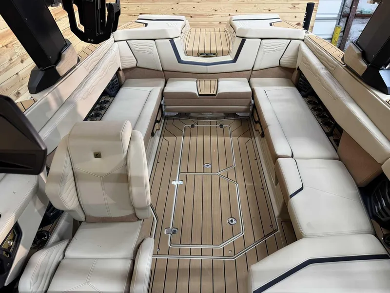 Slide: The Image of 2025 Nautique G25 boat interior with beige seating and wooden flooring. - 9