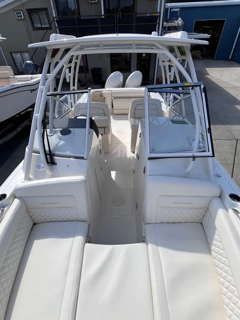Slide: The Image of 2025 Grady-White Freedom 275 boat interior with seating and helm, docked outdoors. - 12