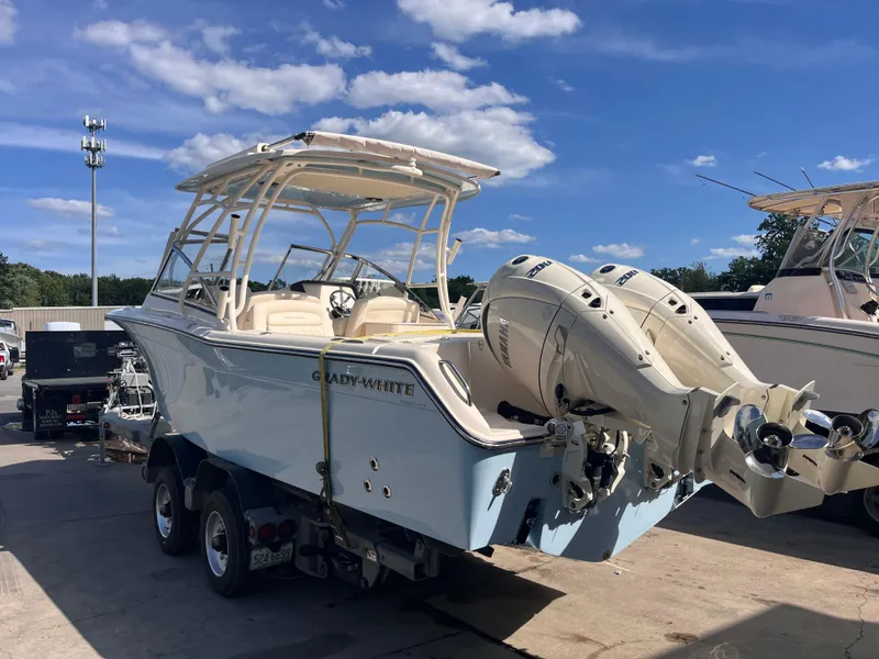 Slide: The Image of 2025 Grady-White Freedom 275 boat with dual engines on a trailer, under a clear blue sky. - 3