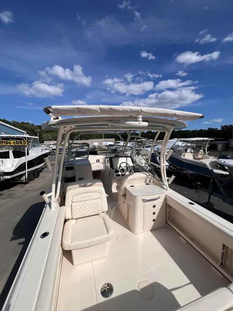 Slide: The Image of 2025 Grady-White Freedom 275 boat with spacious deck and seating under a clear blue sky. - 9