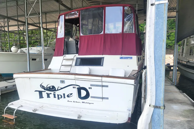 Slide: The Image of 1984 Wellcraft 44 Californian CMY docked, featuring maroon canopy and "Triple D" name on stern. - 12