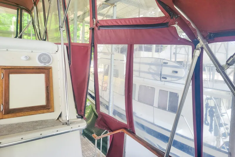 Slide: The Image of 1984 Wellcraft 44 Californian CMY interior with red canopy and docked boats outside. - 28