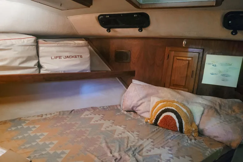 Slide: The Image of 1984 Wellcraft 44 Californian CMY cabin interior with bed, life jackets, and wooden storage. - 45