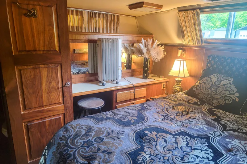Slide: The Image of Cozy 1984 Wellcraft 44 Californian CMY cabin with elegant bedding and warm wooden decor. - 49