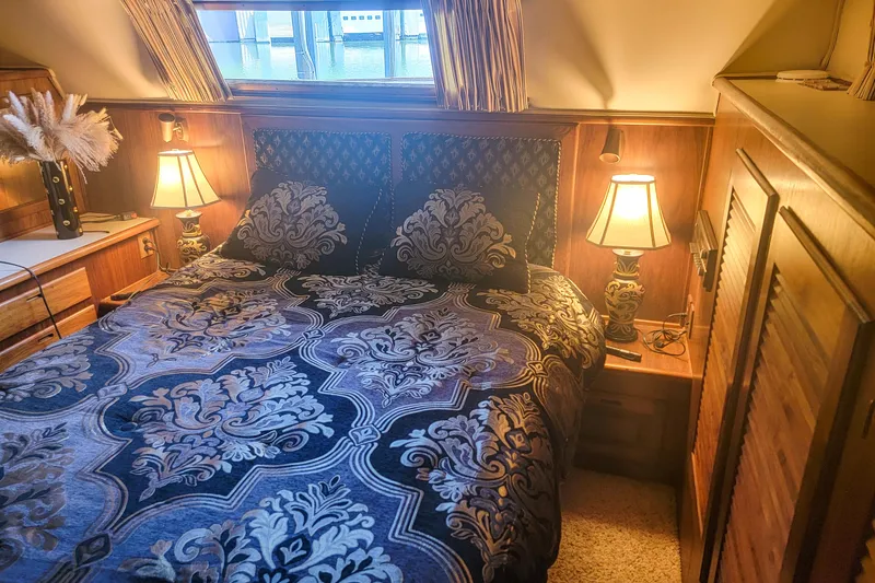 Slide: The Image of Cozy bedroom in 1984 Wellcraft 44 Californian CMY with elegant bedding and warm lighting. - 50
