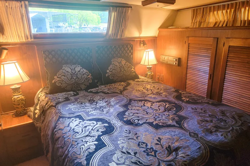Slide: The Image of Luxurious bedroom interior of 1984 Wellcraft 44 Californian CMY yacht with elegant bedding and lamps. - 51