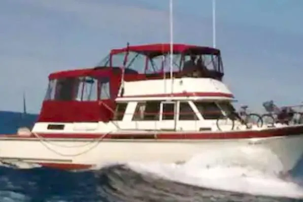 Slide: The Image of 1984 Wellcraft 44 Californian CMY cruising on open water with red canopy. - 6