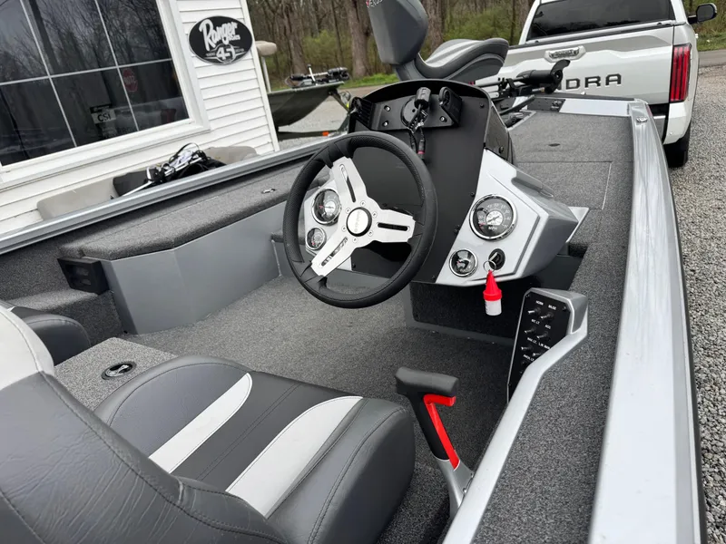 Slide: The Image of 2022 Vexus AVX181 boat interior with steering wheel and seating, parked near a building. - 5